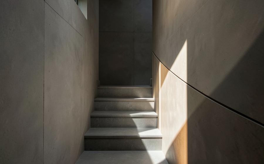 Sunlight crossing a quiet modern stairwell